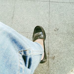 Low section of woman standing on tiled floor