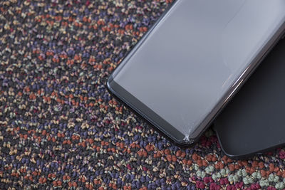 Close-up of damaged smart phone on carpet