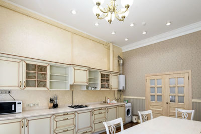 White kitchen set in the house with a large dining room.