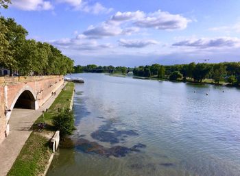 Arch bridge over river against sky