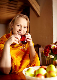 Portrait of happy woman with drink at home