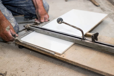 Midsection of man working on metal grate