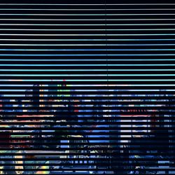 Cityscape seen through window blinds