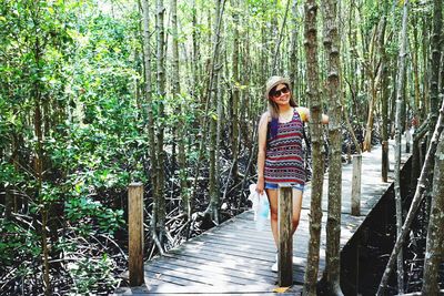 Full length of woman standing on footpath in forest