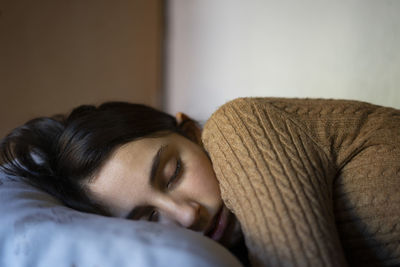 Young girl dressed in brown napping.