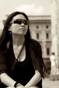 Woman wearing sunglasses while sitting outdoors