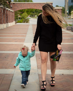 Rear view of young woman walking on street