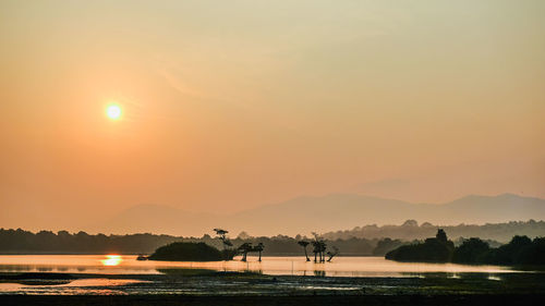 Scenic view of lake against sky during sunset