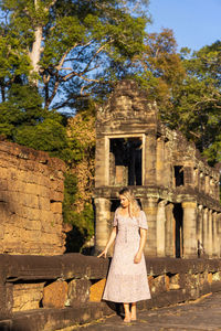 Rear view of woman standing against old building