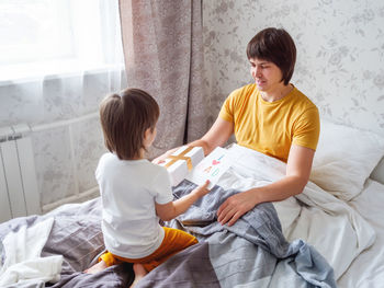 Happy father's day. toddler gives present and handmade greeting card to his dad. 