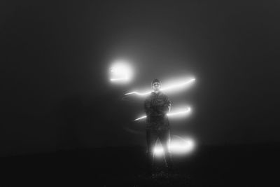 Digital composite image of man and illuminated lights at night