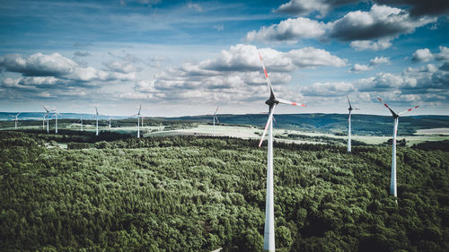 Scenic view of windfarm against sky