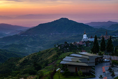 High angle view of buildings and mountains against sky during sunset