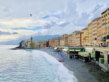 Panoramic view of buildings by sea against sky