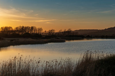 Scenic view of lake against sky during sunset