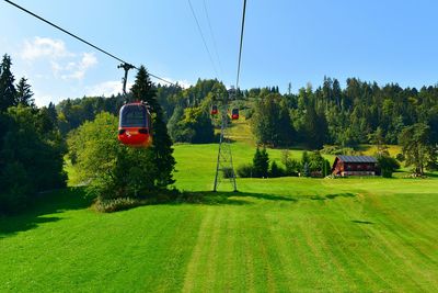 Overhead cable car on land against sky