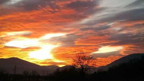 Scenic view of silhouette mountains against romantic sky at sunset