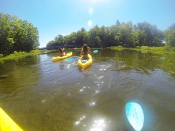 Rear view of people in lake against sky