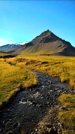 Scenic view of mountain against blue sky