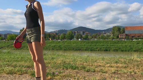 Woman standing on field against sky