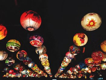 Low angle view of illuminated lanterns hanging at night