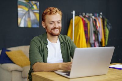 Portrait of young man using laptop at table
