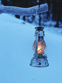 Close-up of illuminated lamp against blue sky