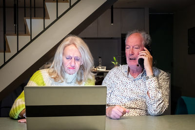 Young woman using mobile phone while sitting at home