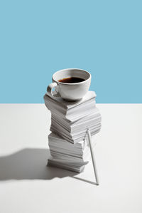 Stack of coffee on table against blue background