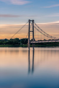 View of bridge over river at sunset