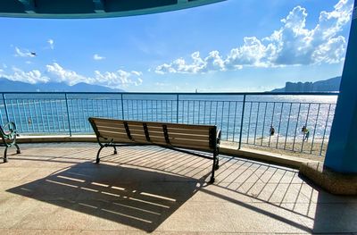 Chairs and table by sea against sky