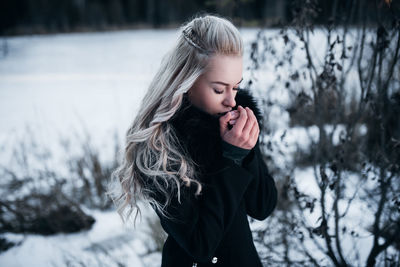 Girl standing on snow covered tree during winter