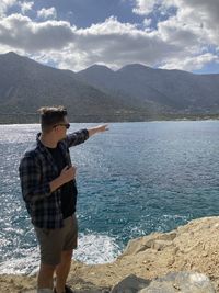 Man standing by sea against mountains