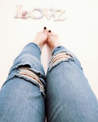 Low section of woman wearing torn jeans