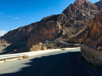 Road by mountains against sky