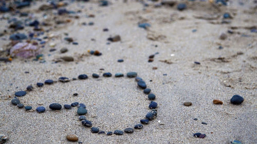 Heart shape made of pebbles at sandy beach