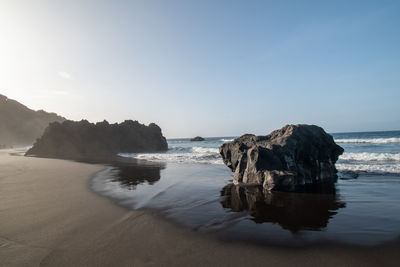 Rocks on beach against sky