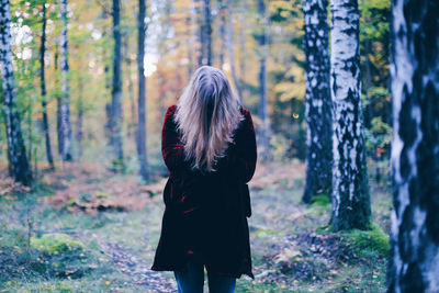 Man wearing coat standing in forest