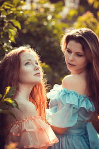 Close-up of young women standing against plants outdoors