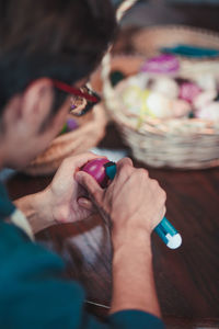 Close-up of man decorating easter egg at home