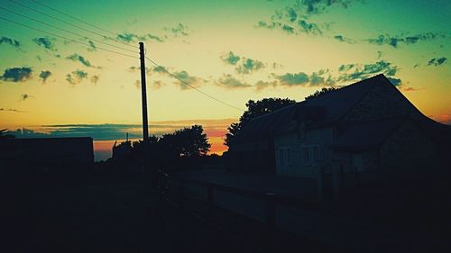 Silhouette of buildings against sky at sunset