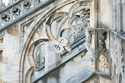 View to spires and statues on roof of duomo through ornate marble fencing. milan, italy