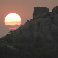 Scenic view of rocks against sky at sunset