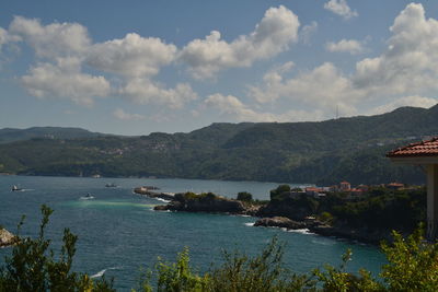 Scenic view of sea and mountains against sky