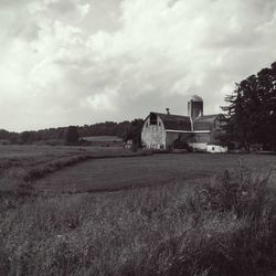 Scenic view of grassy field against cloudy sky