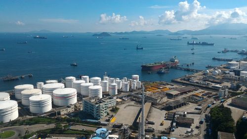 High angle view of city by sea against sky