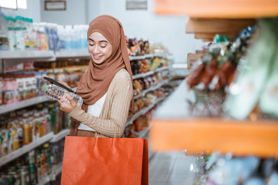 Portrait of young woman standing in store