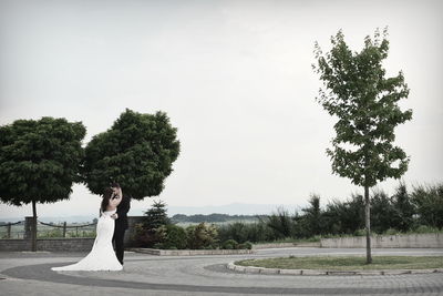 Bride and groom standing on road in city