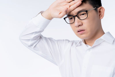 Portrait of boy looking away against white background