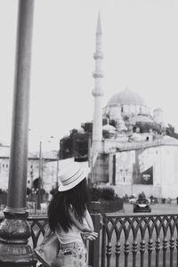 Woman standing by railing in city